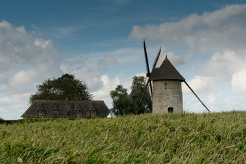 view of the historic windmill Moulin de Pierre and miller's house in Hauville in Normandy