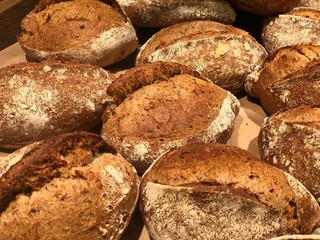 A lot of baked round bread. Fresh wheat bread on a shelf in the store. Background texture: daily bread.