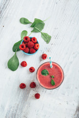 flat lay of healthy raspberry smoothie on white wooden table with copy space