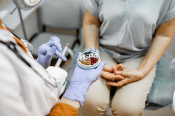 Doctor giving some medicine to a patient in the gynecological office, close-up view on the hands and pills