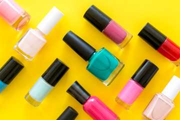 Nail polishes background on yellow table top view pattern