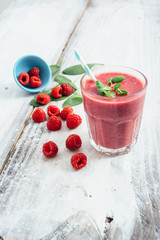 healthy raspberry smoothie on white wooden board with copy space