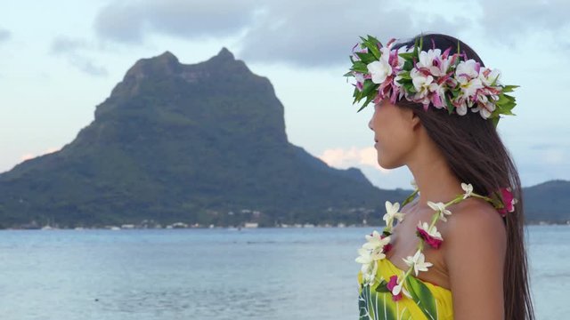 Tahiti flower crown hei poo smiling woman wearing tahitian headpiece wreath cultural decoration. Mount Otemanu, Bora Bora, French Polynesia. Beauty Asian multiracial model smile - travel vacation icon