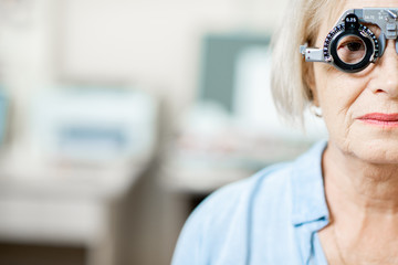 Close-up of a senior woman checking vision with eye test glasses during a medical examination at...