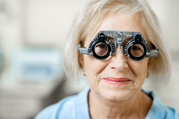 Close-up of a senior woman checking vision with eye test glasses during a medical examination at...