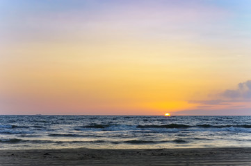 Sunset over the sea. Reflection of sunlight in the sea waves. The sky in the sunset rays.