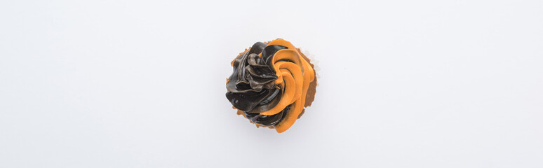 Fototapeta premium top view of delicious Halloween black and orange cupcake isolated on white, panoramic shot