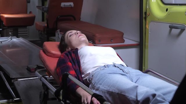Senseless woman lie on the stretcher.