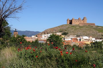 Fototapeta na wymiar View of the castle on the hilltop with town buildings in the foreground, La Calahorra, Spain.