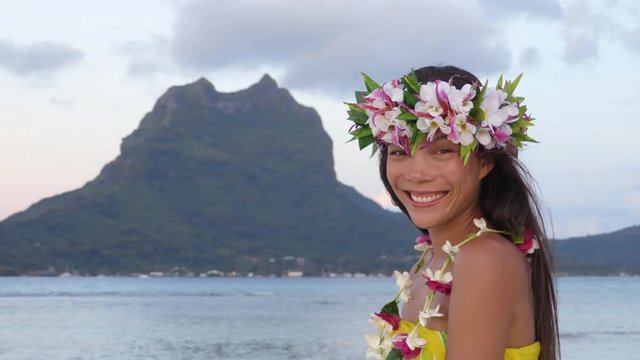Tahiti flower crown hei poo smiling woman wearing tahitian headpiece wreath cultural decoration. Mount Otemanu, Bora Bora, French Polynesia. Beauty Asian multiracial model smile - travel vacation icon