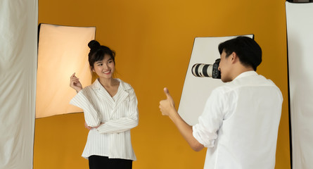 Photographer working with model in studio with equipment