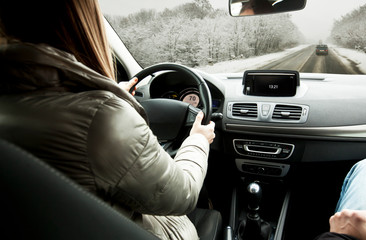 Woman driving the car on snowy road