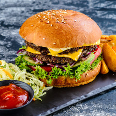 Fresh homemade burger with grilled potatoes, served with ketchup sauce