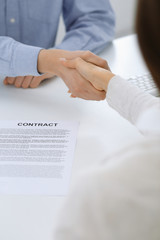 Business people shaking hands at meeting or negotiation after contract discussing. Businessman and woman handshake at office while sitting at the desk. Success concept