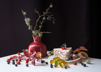 Autumn still life with cake on black background
