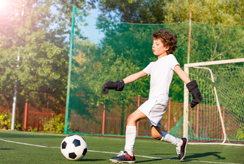 Summer soccer tournament for young kids. football club. emotions and joy of the game. Young goalie. Kids - soccer champion. Boy goalkeeper in football sportswear on stadium with ball. Sport concept.