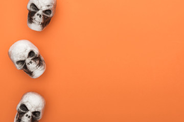 top view of decorative skulls on orange background with copy space