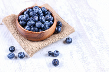 Fresh blueberries in a wooden bowl on burlap