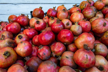 Fresh whole fruits of pomegranate stacked at market stall in Sirince village in Izmir province in Turkey. Healthy fresh fruits. Selective focus.