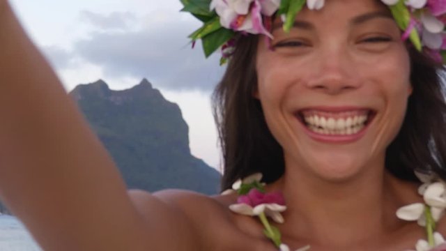 Polynesia tahiti travel icon - Polynesian Welcome with traditional flower Lei. Woman wearing flower head crown giving leis flower necklaces as welcoming gesture for tourism. Mount Otemanu, Bora Bora.
