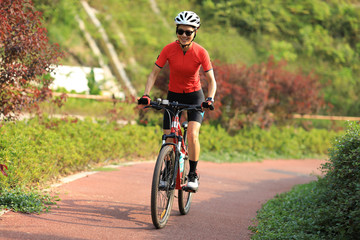 Woman cyclist riding mountain bike on bike path