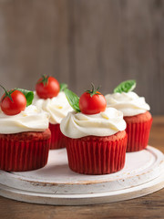 Savory unsweetened tomato spice cupcakes snacks with cream cheese frosting on wooden background. Space for text. Selective focus. Different Appetizers, starters decor for party.