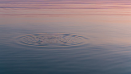 Amazing sunset reflected in calm mirrored water surface.