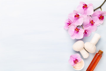 Sea salt, aromatherapy oil in bottles and orchid on vintage wooden background.