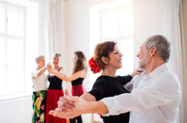 Group of senior people in dancing class with dance teacher.