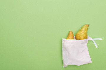 top view of pears in eco friendly white bag isolated on green