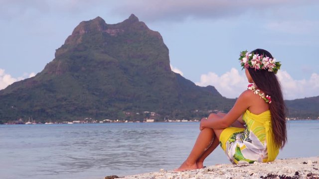 Tahiti Polynesia travel destination icon - French Polynesian Bora Bora Otemanu and woman wearing traditional head flower crown and pareo . Travel holidays concept. RED cinema camera SLOW MOTION.