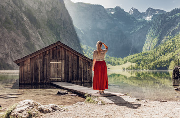 Junge Frau an Bootshütte am Obersee Berchtesgaden - obrazy, fototapety, plakaty