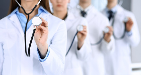 Group of doctors holding stethoscope head close-up. Physicians ready to examine and help patient. Medical help, insurance in health care, best treatment and medicine concept