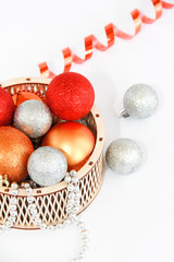 shiny multi-colored Christmas balls toys in a decorative wooden basket for the New Year holiday