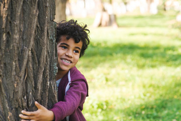 African American boy preschooler with curly hair walks in the park