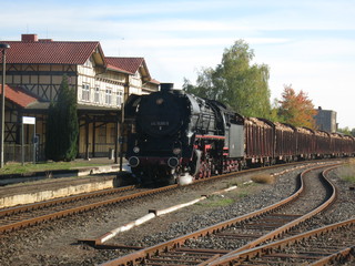 Obraz premium Pociąg towarowy rusza, lokomotywa parowa