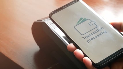 4K. contactless payment, customer paying bill through smartphone using NFC technology at point of sale terminal during shopping time. mobile digital wallet technology concept - Powered by Adobe