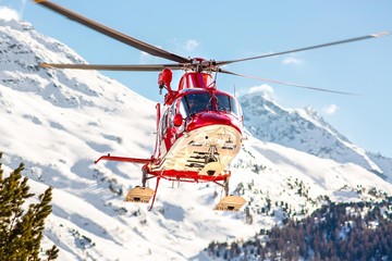 Rettungshelikopter startet mit Alpenpanorama im Hintergrund