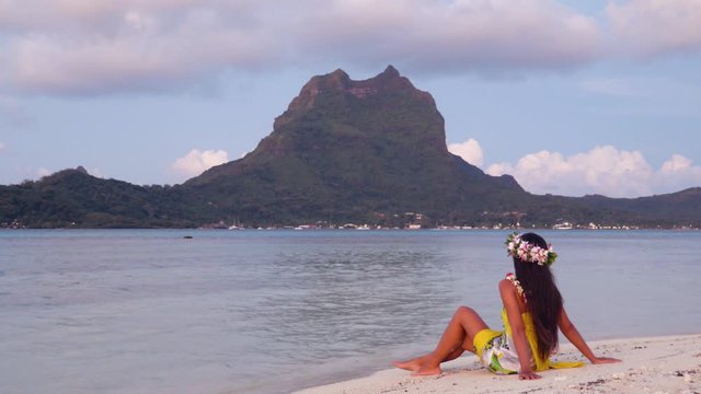 Tahiti Polynesia travel destination icon - French Polynesian Bora Bora Otemanu and woman on motu beach wearing traditional head flower crown and pareo . Travel holidays concept.