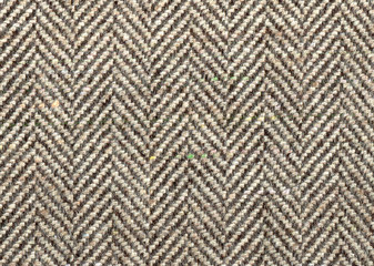 Lighte Brown woolen fabric striped zigzag. Herringbone tweed, Cashmere Background Texture. Coat close-up. Expensive men's suit fabric. High resolution