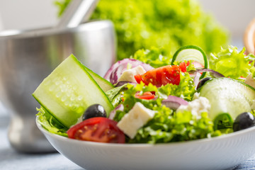 Salad with fresh vegetables olives tomatoes red onion greek cheese feta and olive oil.