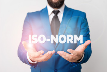 Text sign showing Iso Norm. Business photo showcasing An accepted standard or a way of doing things most showing agreed Man with opened hands in fron of the table. Mobile phone and notes on the table