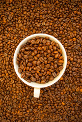 cup with coffee beans and cinnamon sticks	