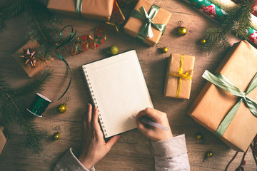 Wish list on table with wrapped Christmas gift