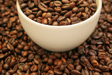 cup with coffee beans and cinnamon sticks	