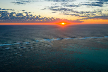 Aerial photo of sunset over sea and coral reef