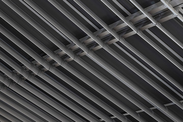 Angular view close-up of dark metal beams structure in ceiling of building