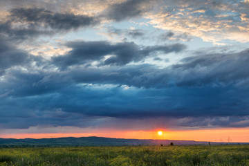 Colorful sunset with rain at sun horizon