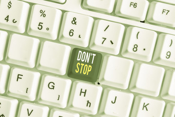 Word writing text Don T Stop. Business photo showcasing Continue what had been doing without rendering a delay White pc keyboard with empty note paper above white background key copy space