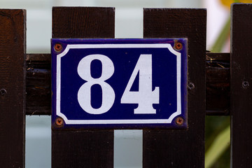 House number 84 on a wooden gate